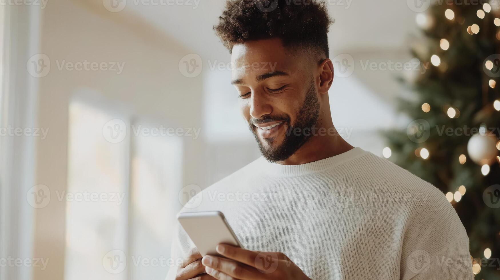 a in a white sweater uses a smartphone while standing by Man sunlit window, surrounded by soft curtains and indoor plants photo