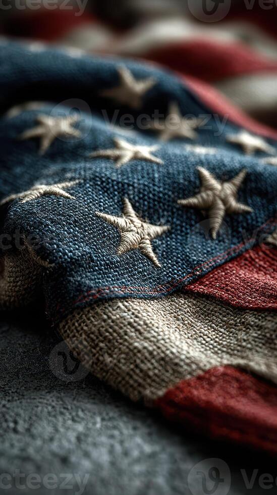 Tattered United States flag with stitched stars draped over a rough surface showing pride and history photo