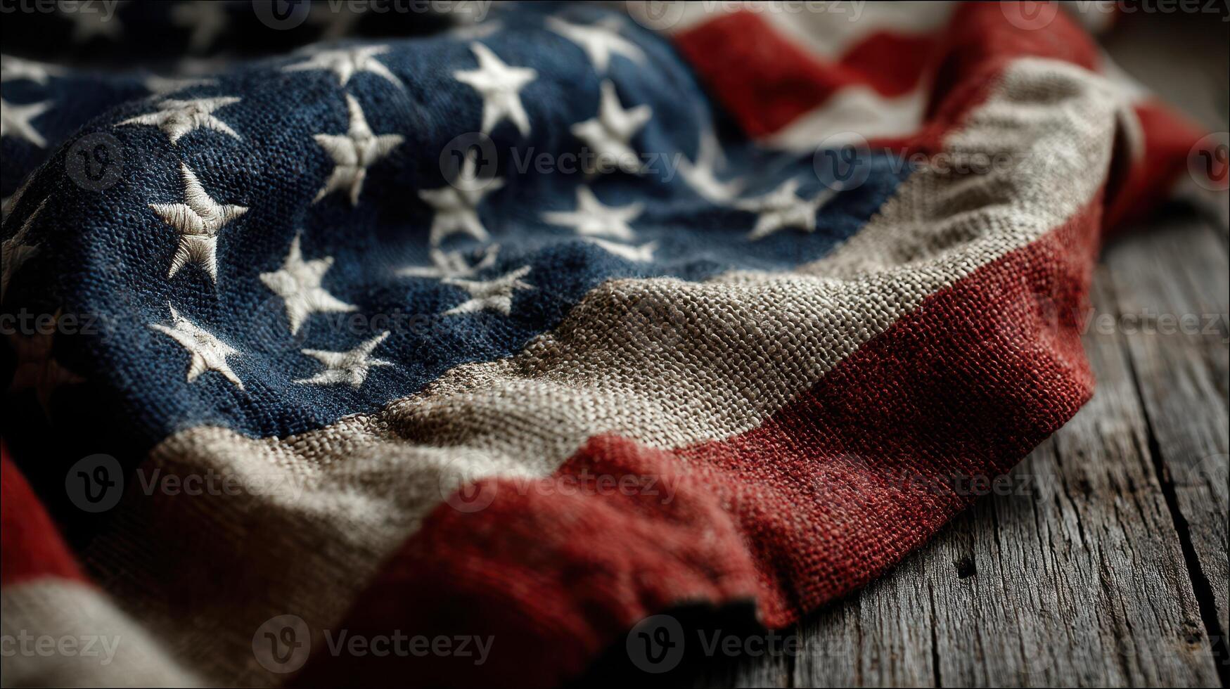 Worn American flag draped over rustic wooden surface highlighting the texture and colors of the fabric in natural light photo