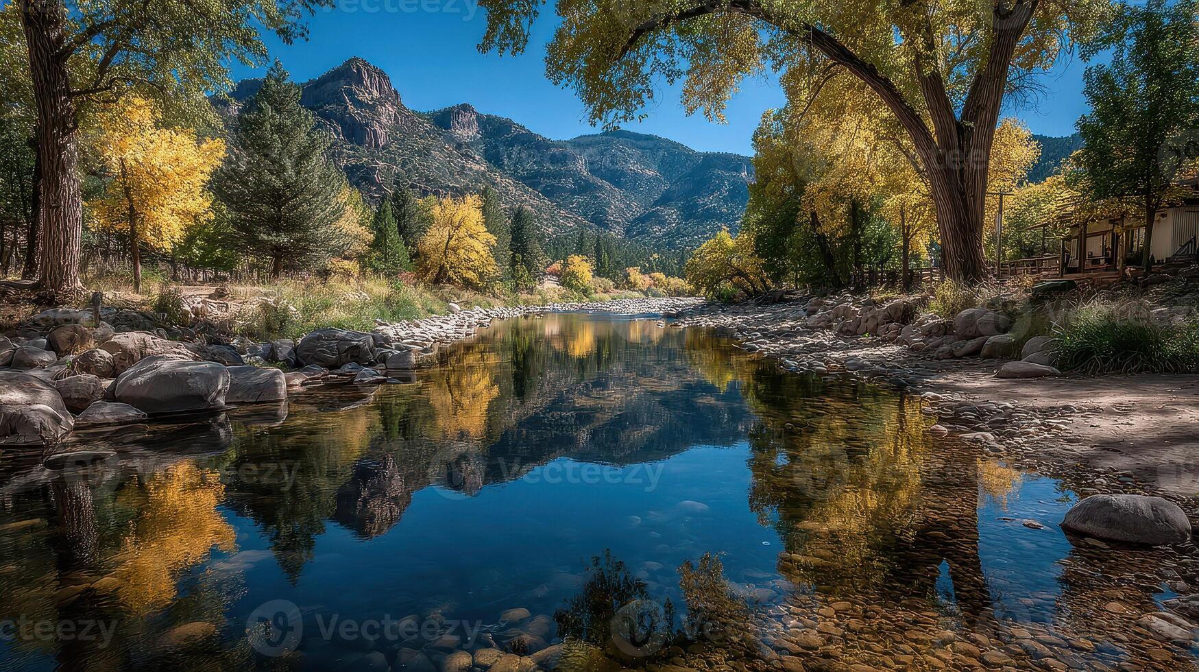 Scenic river reflecting autumn foliage in a mountainous landscape during midday light photo