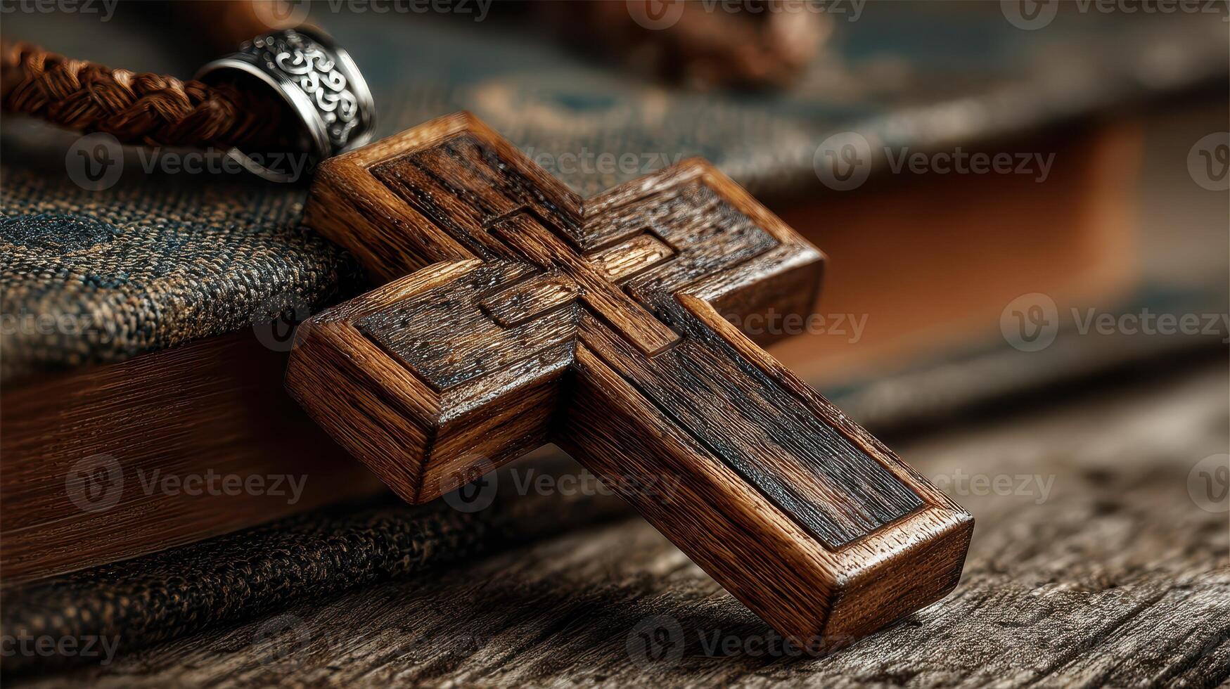 Wooden cross pendant resting on an ancient book with a textured cover and natural lighting highlighting its details photo