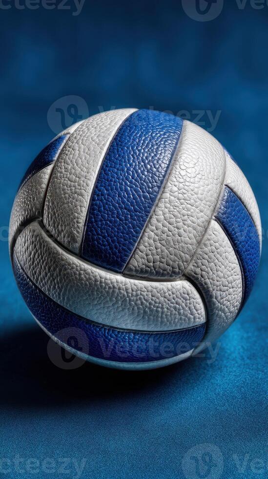 Detailed close-up of a blue and white volleyball resting on a textured surface with a smooth finish photo