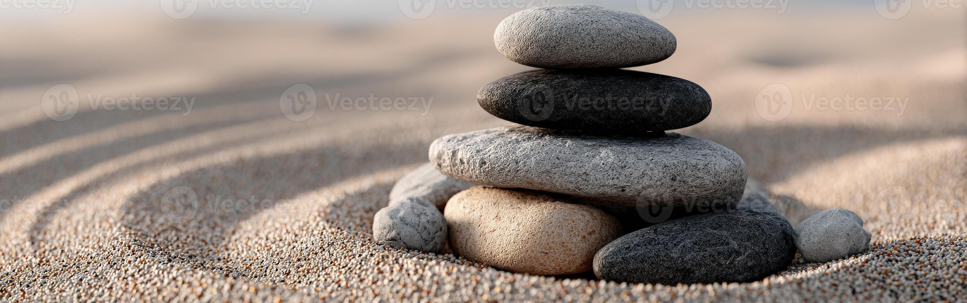 Stacked stones on a tranquil sandy surface create a calming atmosphere photo