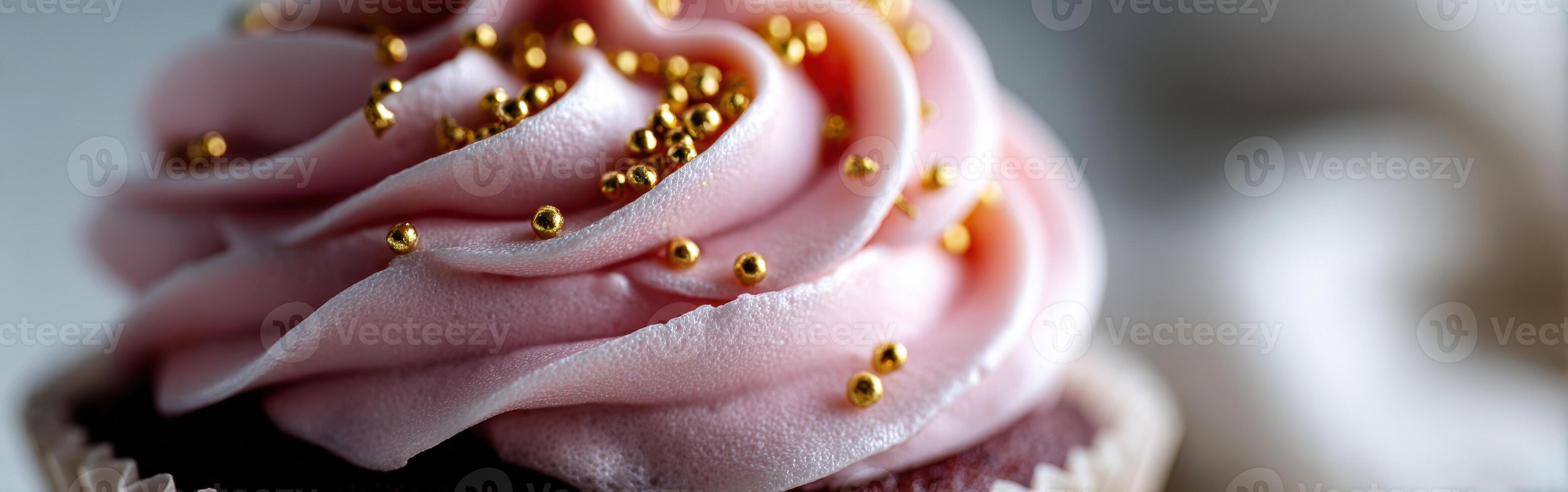 Delicious pink frosted cupcake with golden sprinkles displayed close up photo