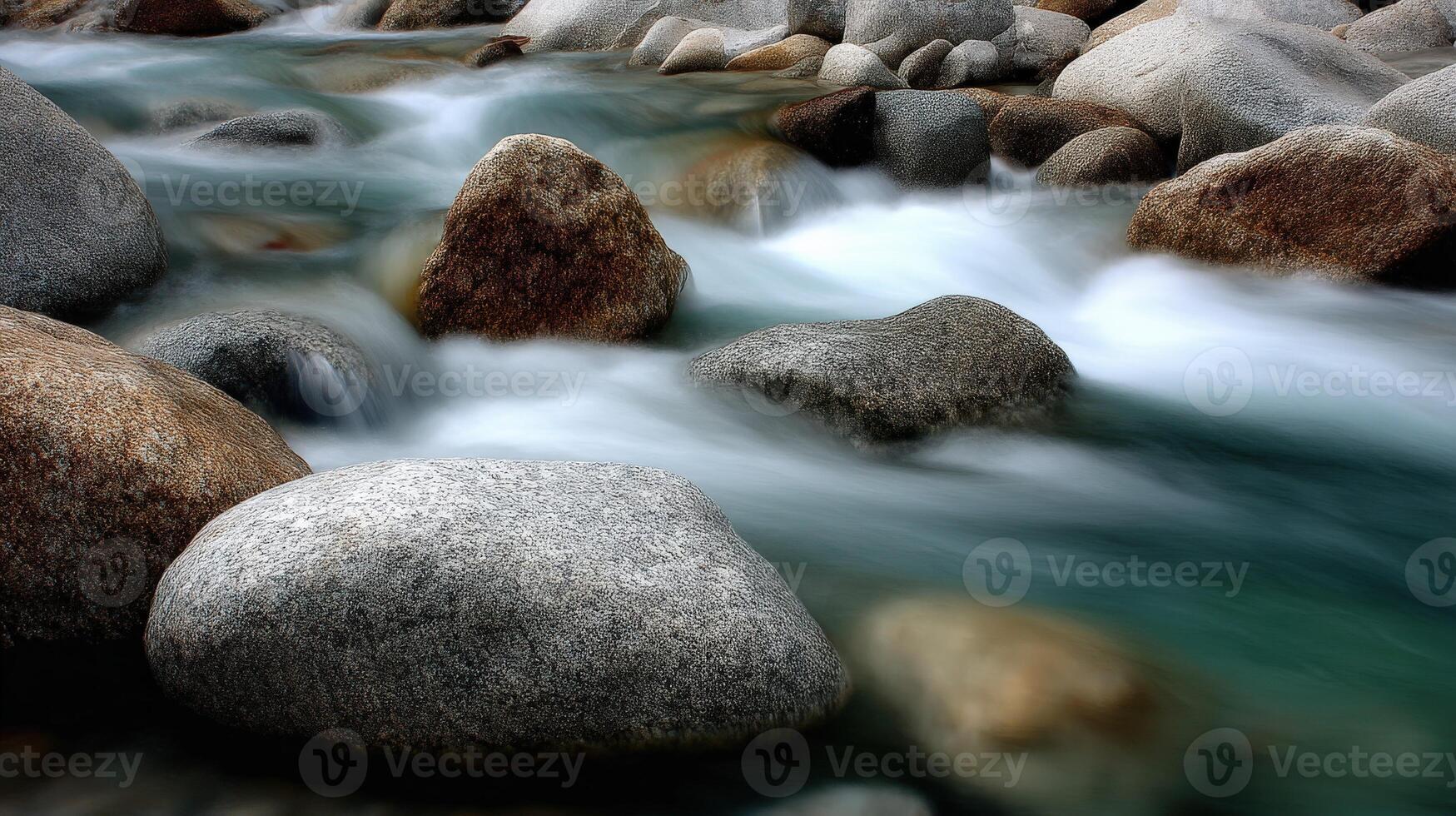 Water flows among smooth rocks and boulders in a river photo