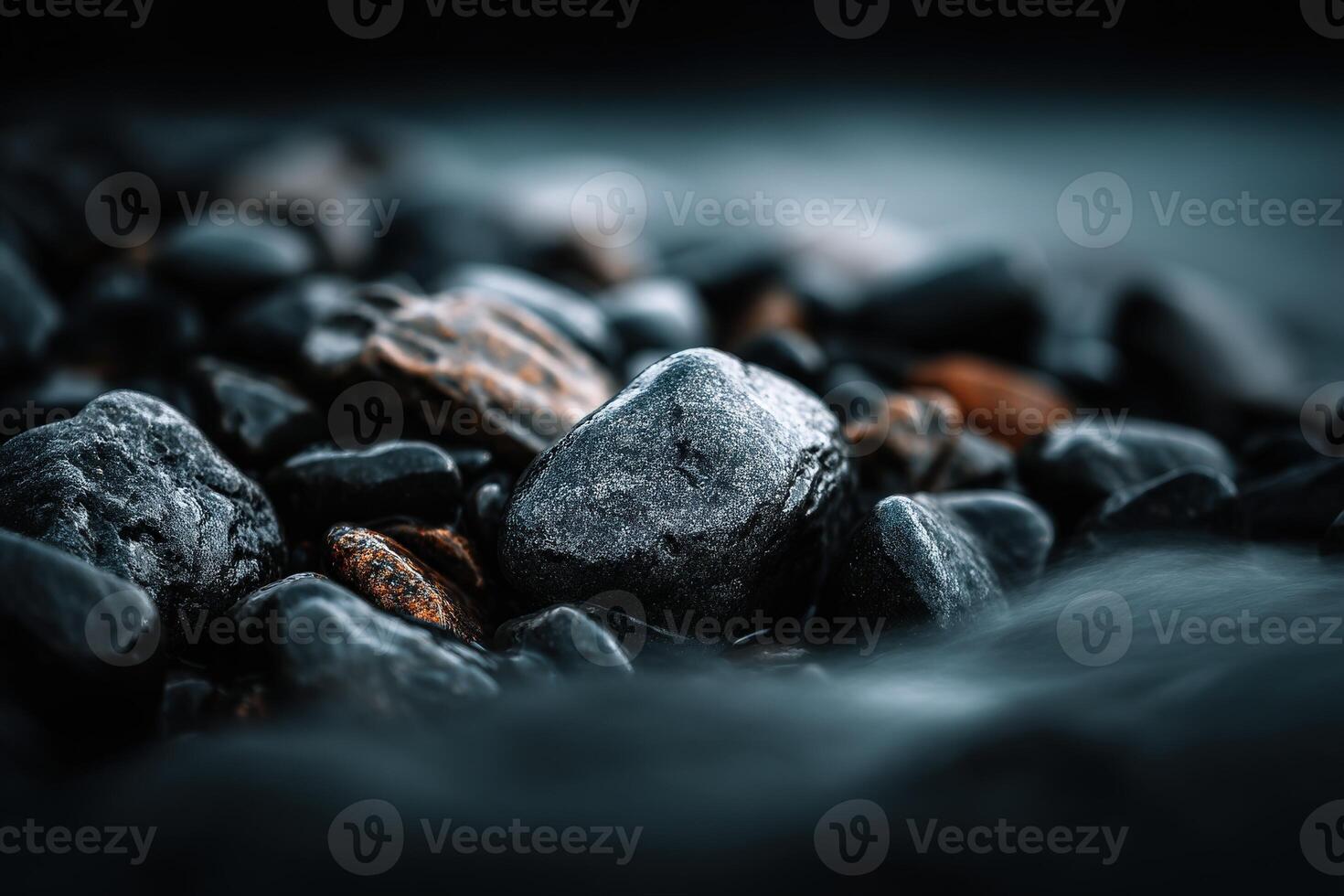Dark wet pebbles and small rocks on a beach at dusk photo