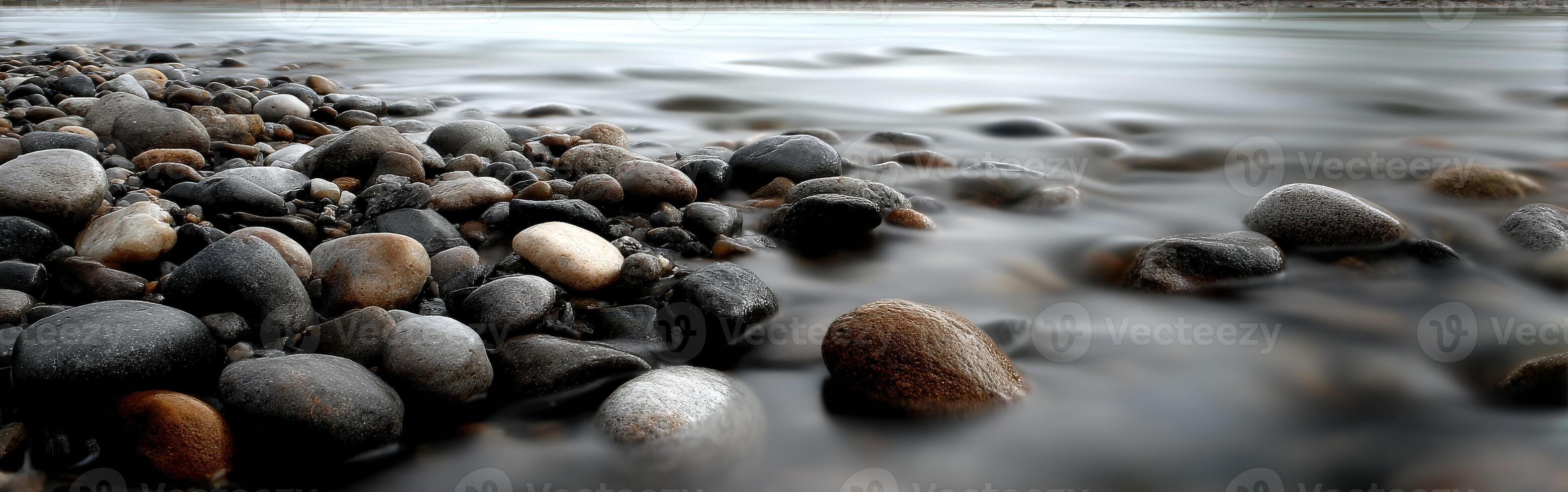 Rocks and smooth flowing water at a river's edge photo