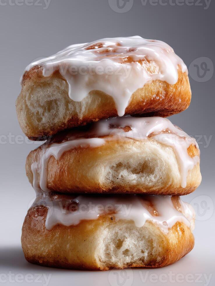Stack of three glazed cinnamon rolls on a light background photo