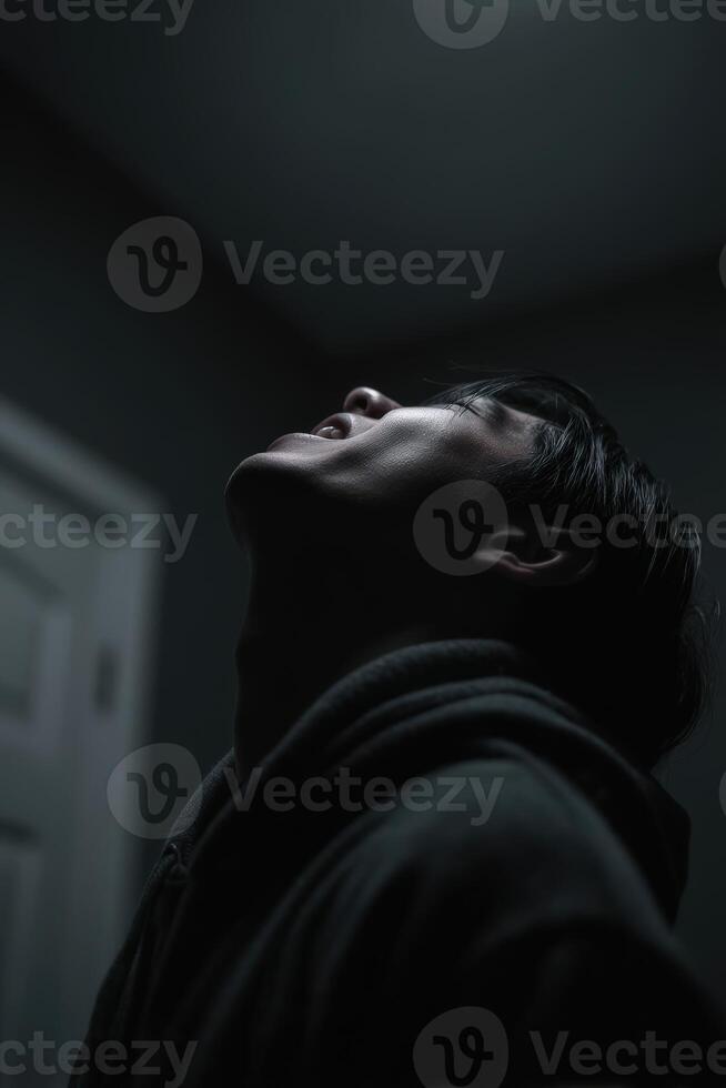 Low angle of Man looking up in dark indoor space photo