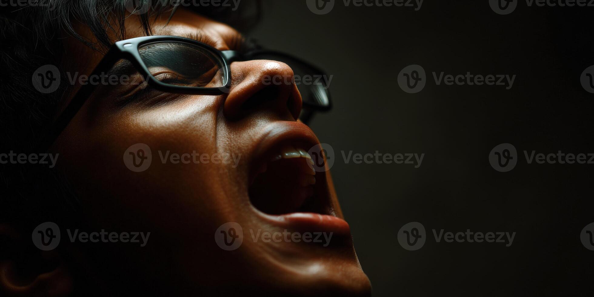 Man with glasses screams in anguish toward the sky photo