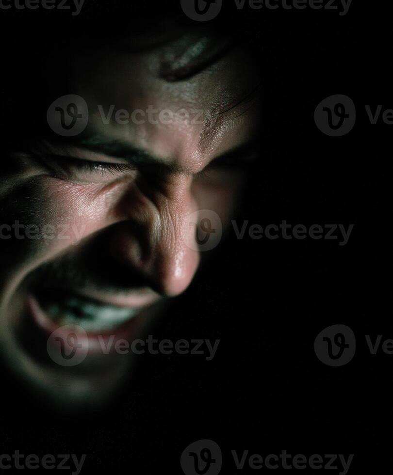 Intense close-up of angry Man's face in the Dark photo