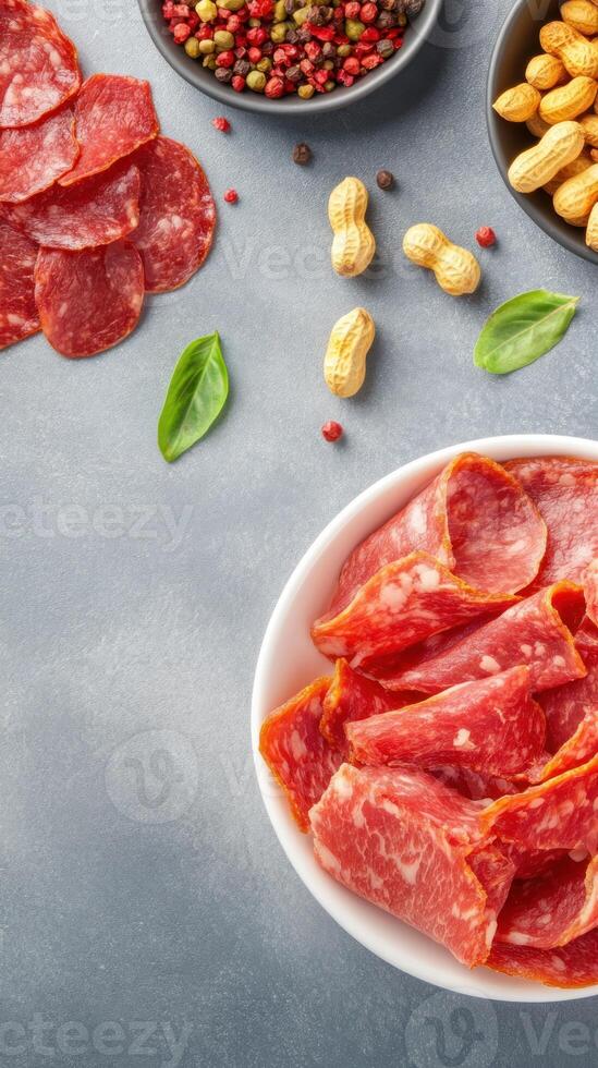 Appetizers of salami, nuts and peppers on a table ready to be enjoyed in a light atmosphere photo
