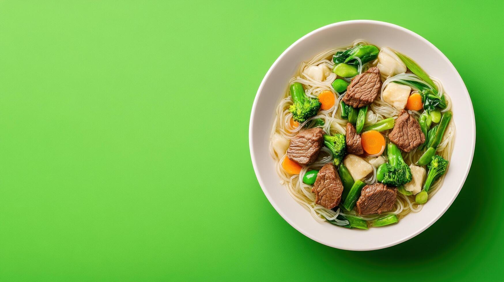 Beef and vegetable soup. Healthy meal for lunch in a white plate on a green background photo