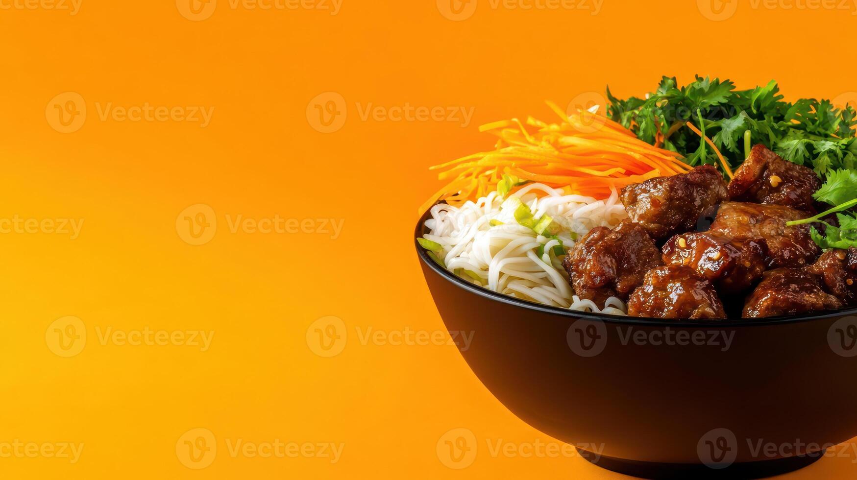 Bowl of meat and vegetables on a bright orange background, ready to be served at the dinner table photo