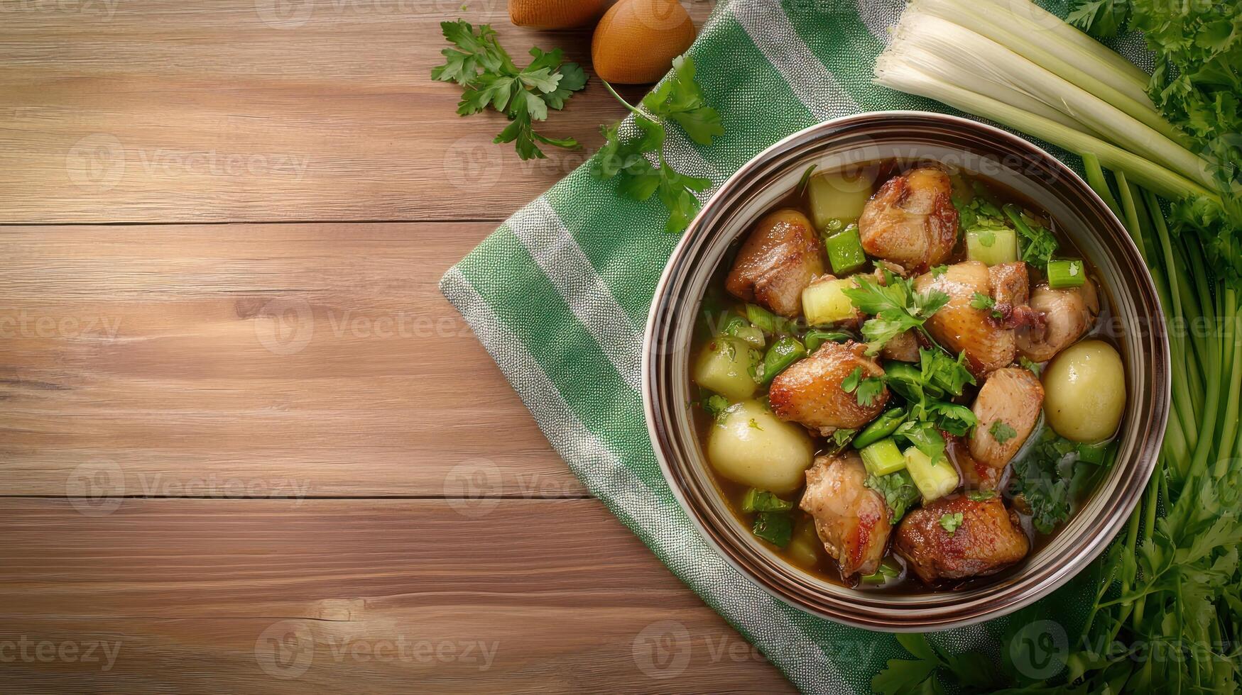 Chicken stew with potatoes, celery and parsley in a bowl on a wooden table with eggs in the background photo