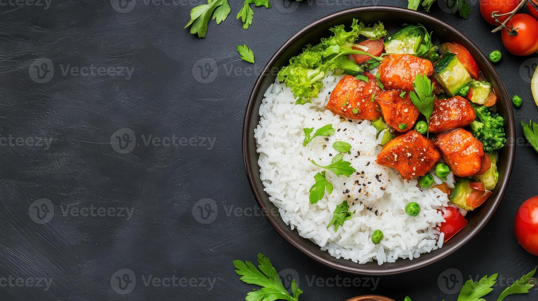 Delicious rice bowl meal with chicken, vegetables and healthy salad on a dark surface for healthy eating photo