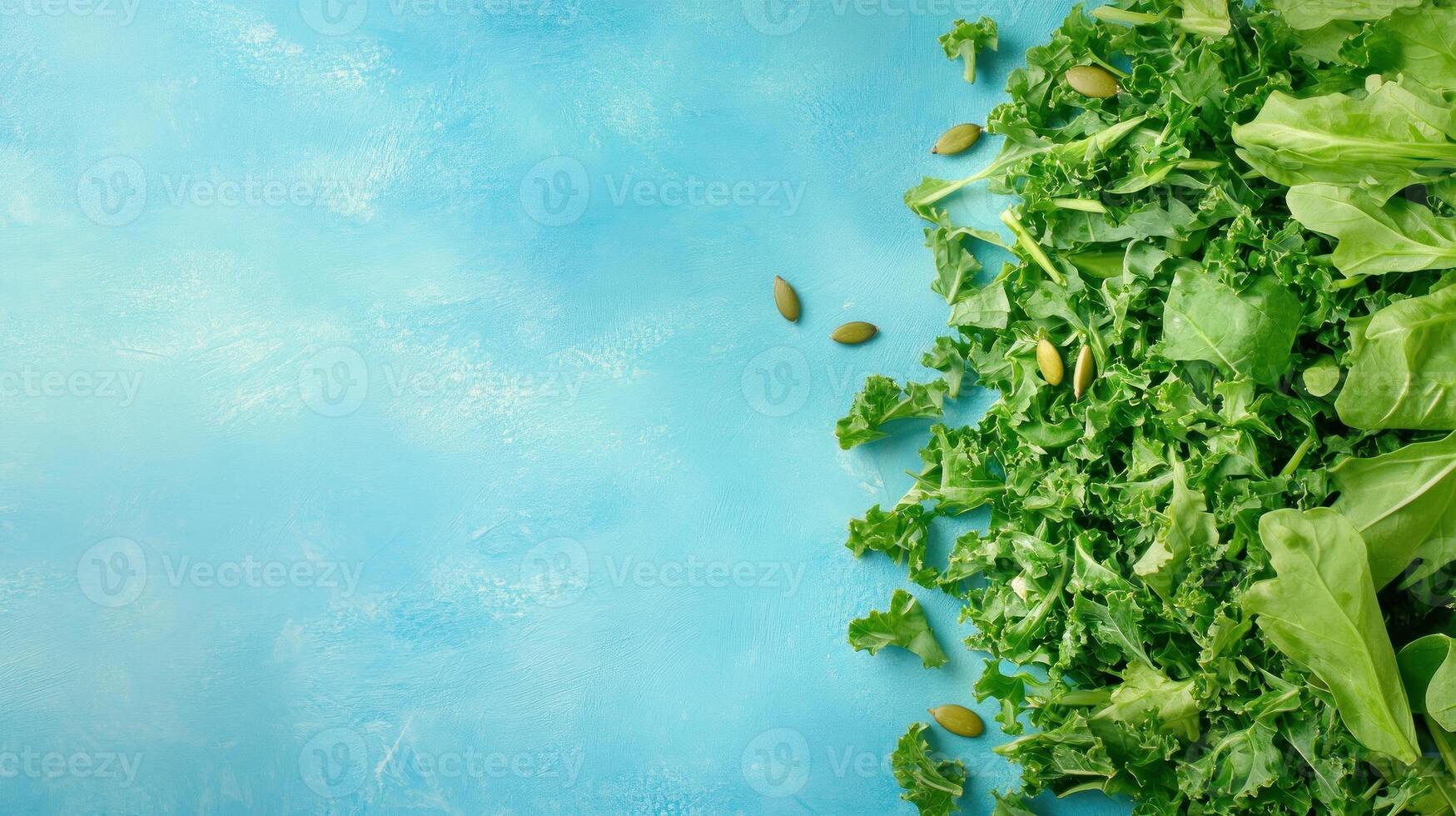 Fresh green kale and arugula salad mix with pumpkin seeds on a bright blue backdrop for healthy eating photo
