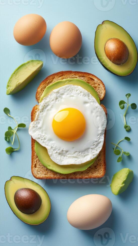 Healthy breakfast fried egg and avocado on toast, with greens, on a blue background. For editorial use photo
