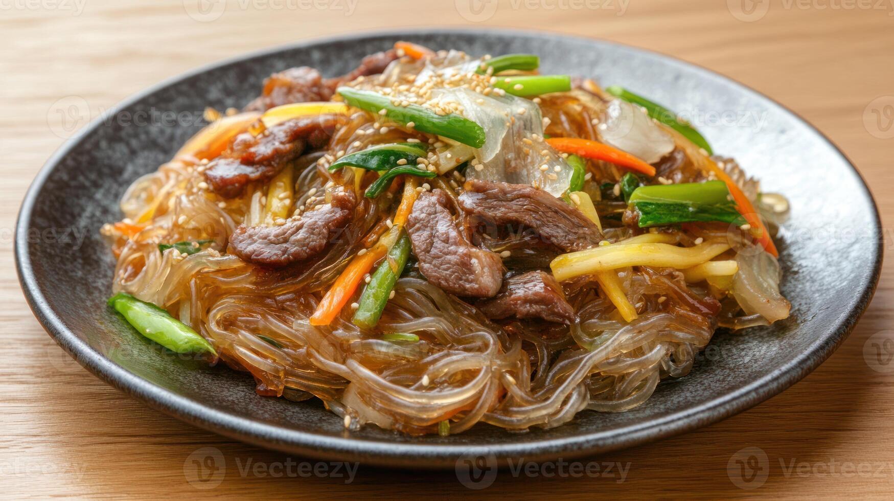 Japchae served. Noodles, beef, and vegetables on the plate. Food presentation photo