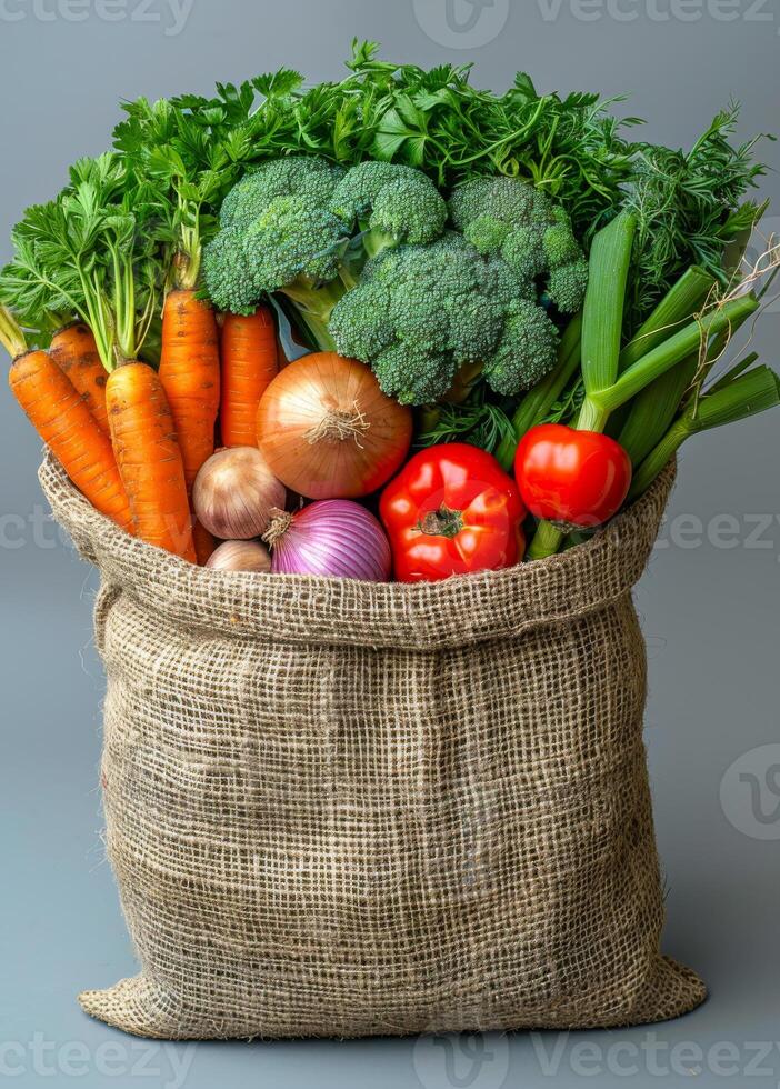 Fresh veggies in burlap sack. A burlap sack filled with various fresh vegetables, showcasing vibrant colors and natural textures. photo