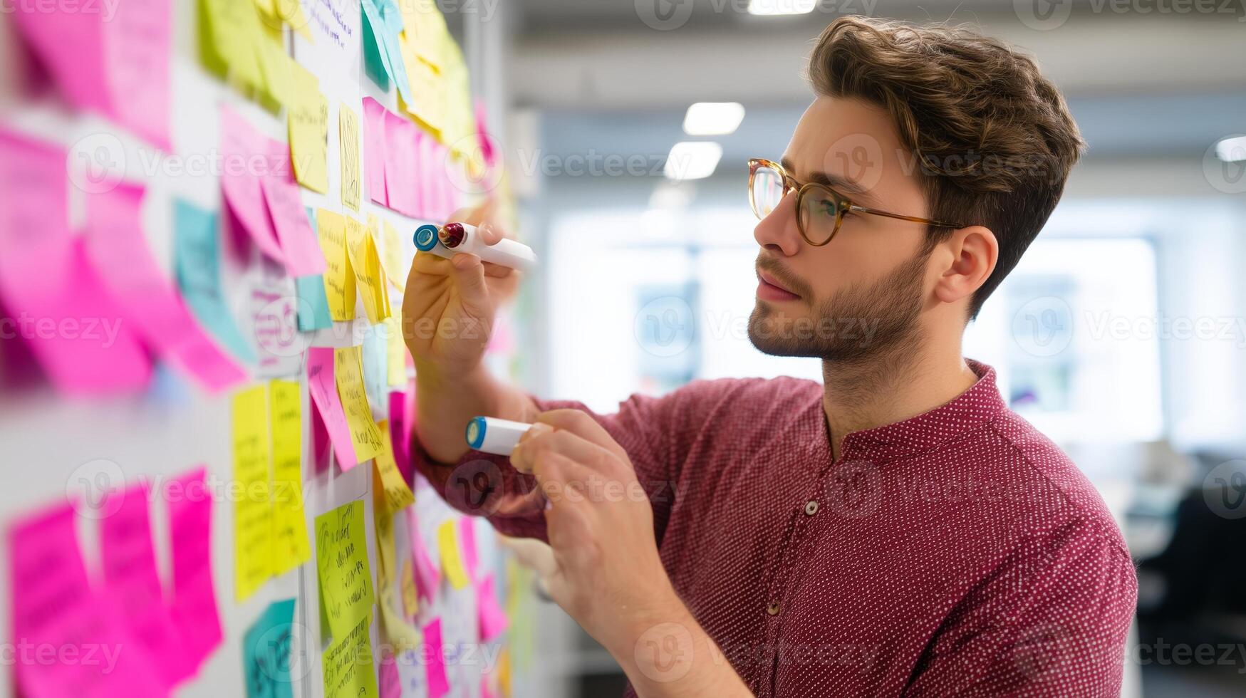 Creative brainstorming session in a modern office with sticky notes and a focused young man photo