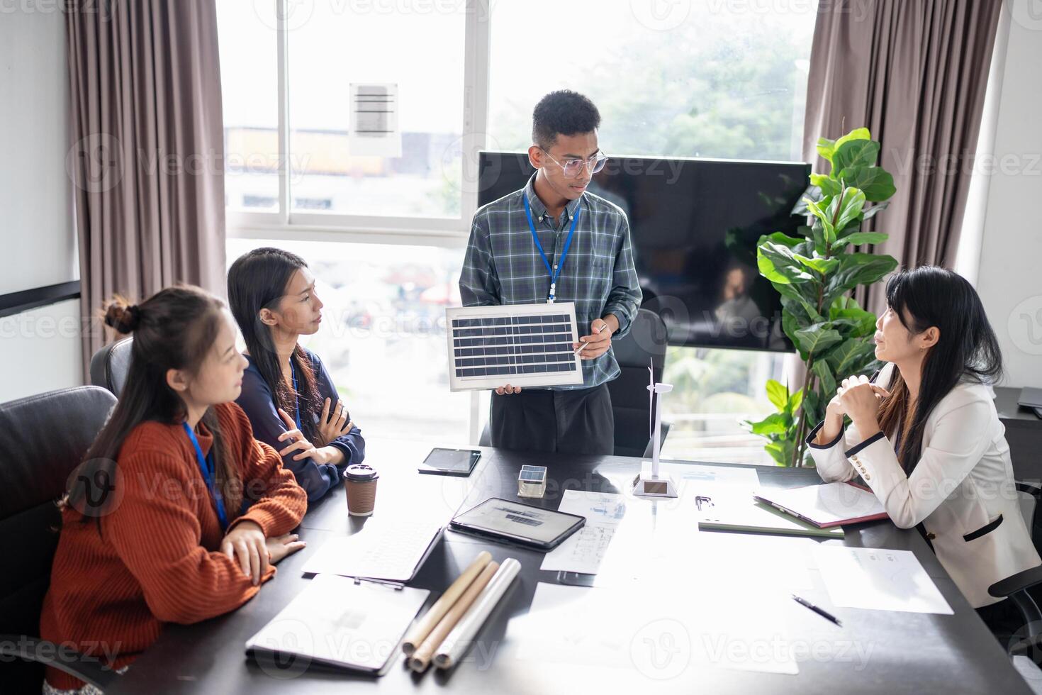 Solar panels green energy a group of engineers sitting around a table with a laptop photo