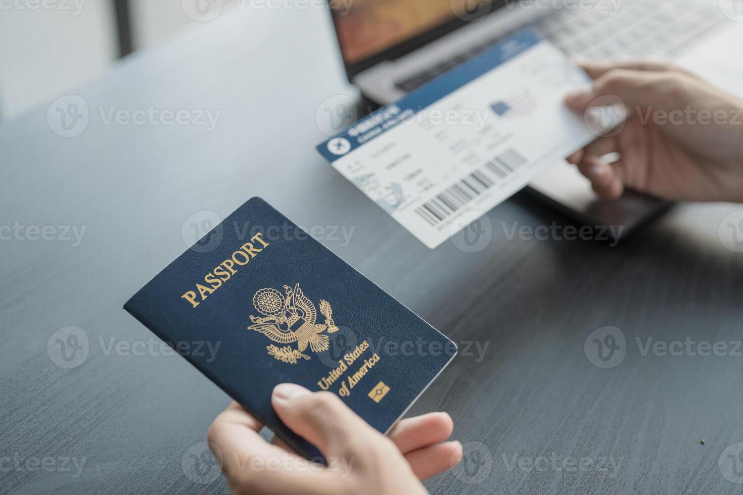 Hand Man booking and buying plane tickets using laptop phone and credit card Planning trip travel vacation with passport and ticket photo