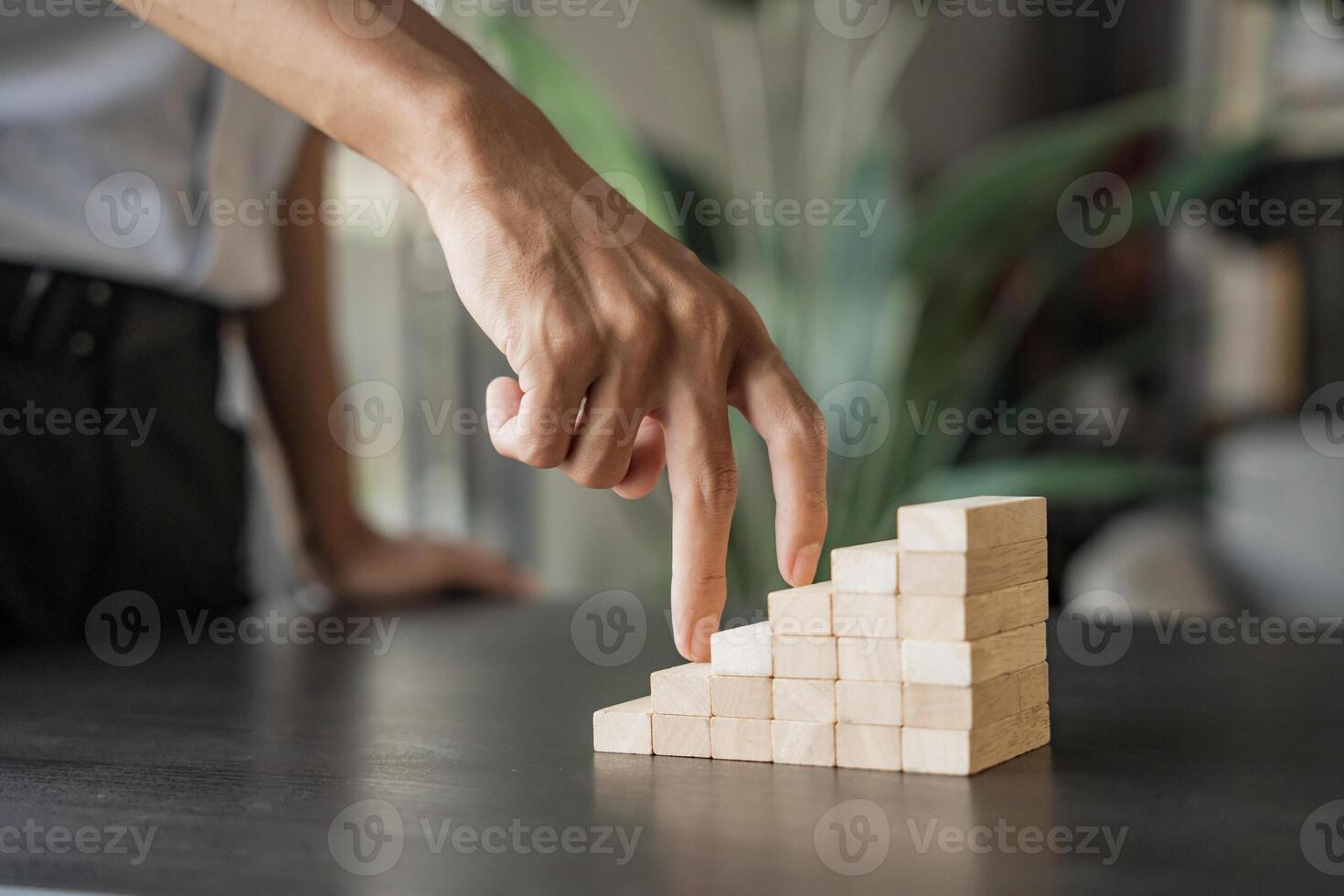 a businessman is placing wooden blocks on a table photo