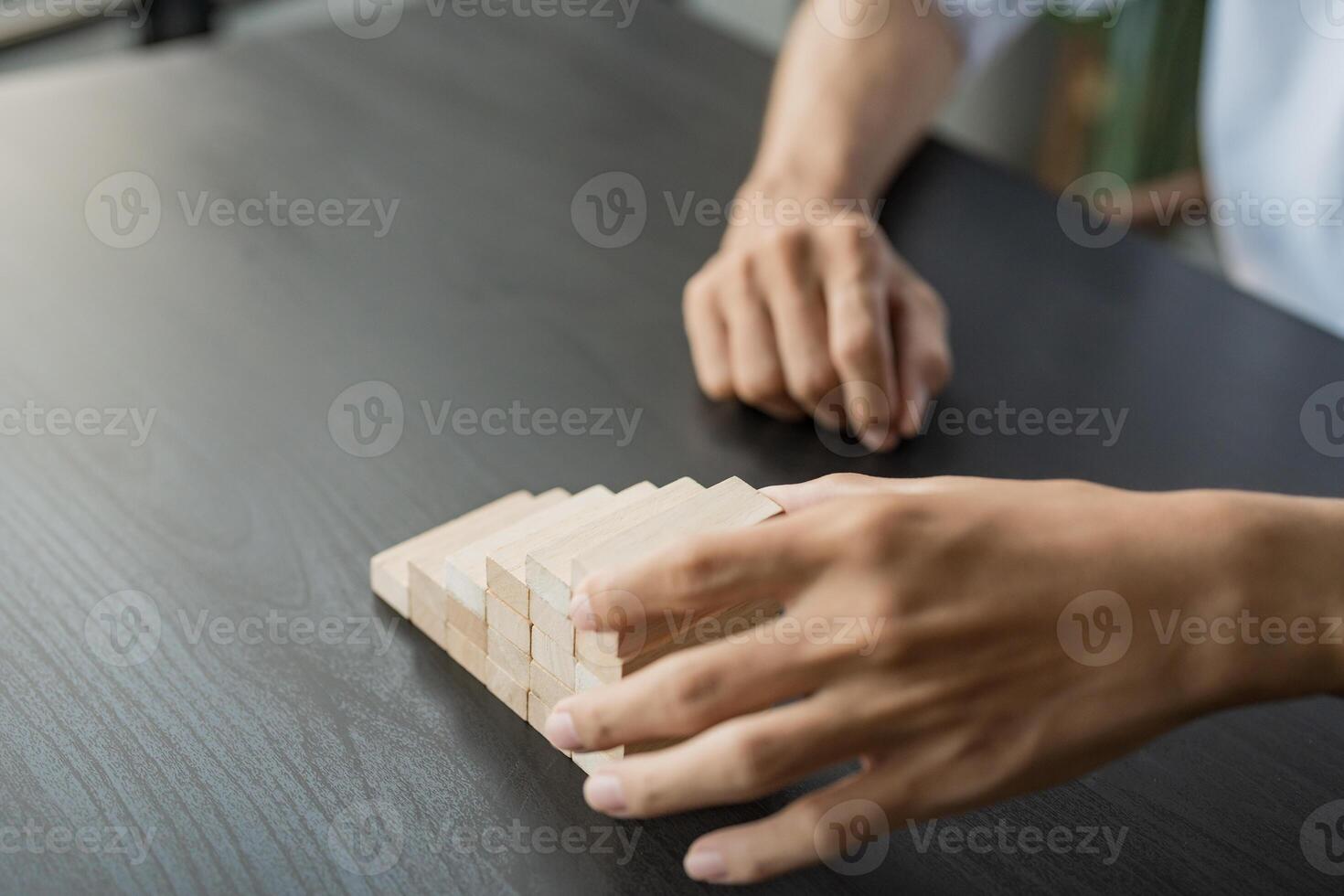 a man is placing wooden blocks on a table photo