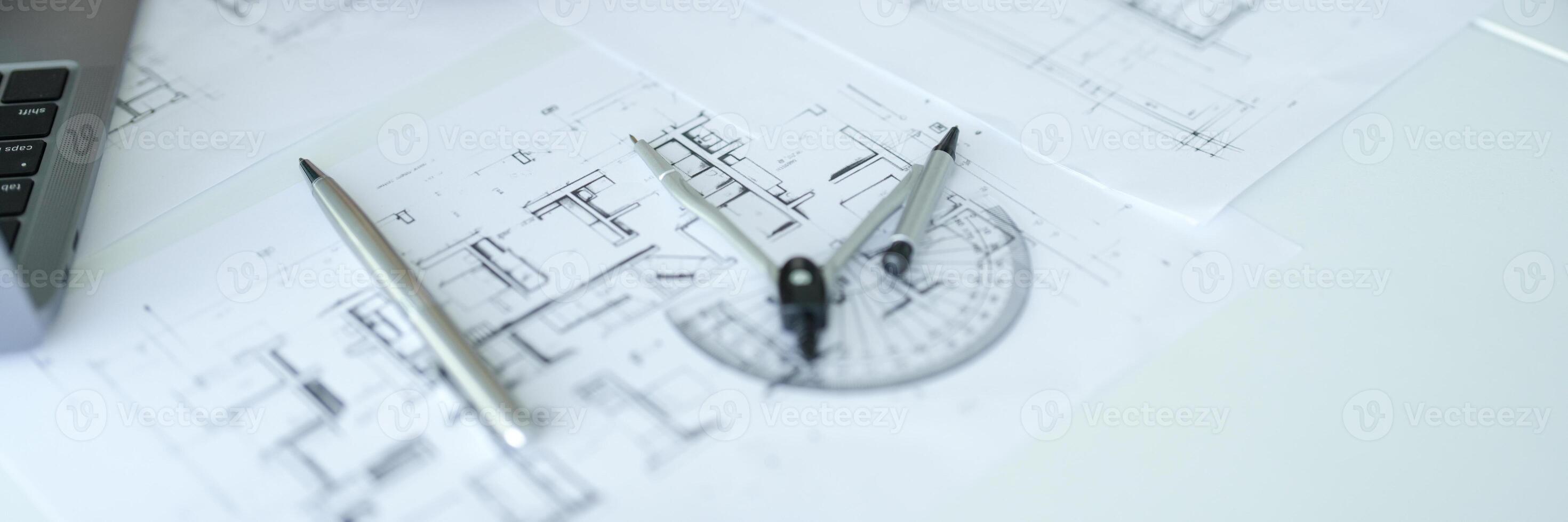 a laptop computer and a pencil on top of blueprints photo