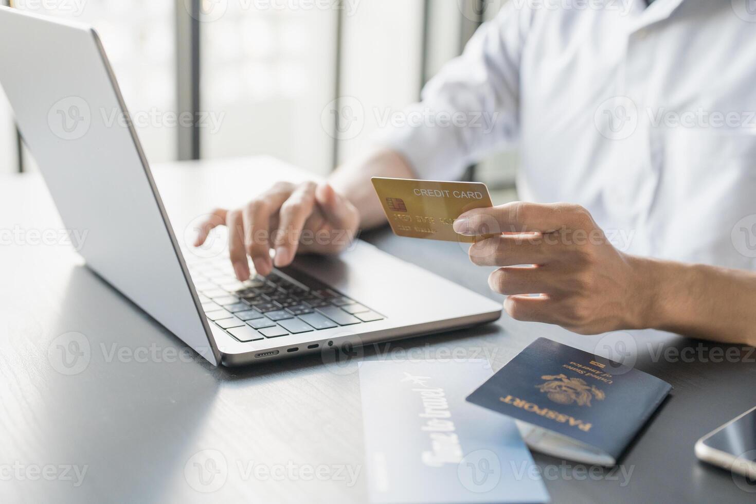 man using laptop and credit card to pay for online ticket photo
