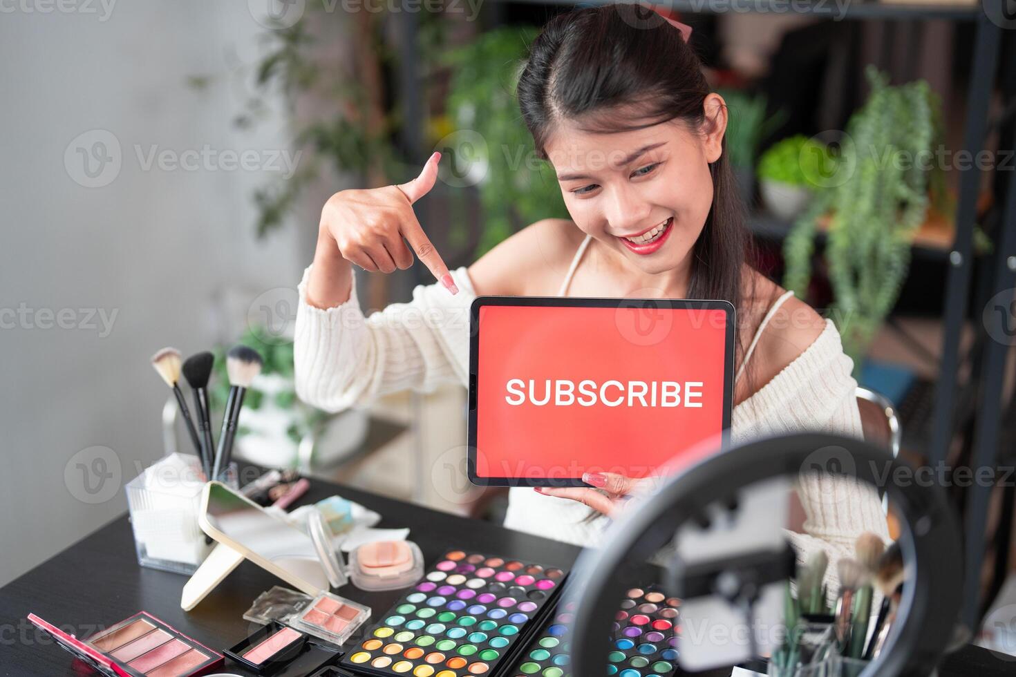 woman holding a tablet with subscribe sign photo