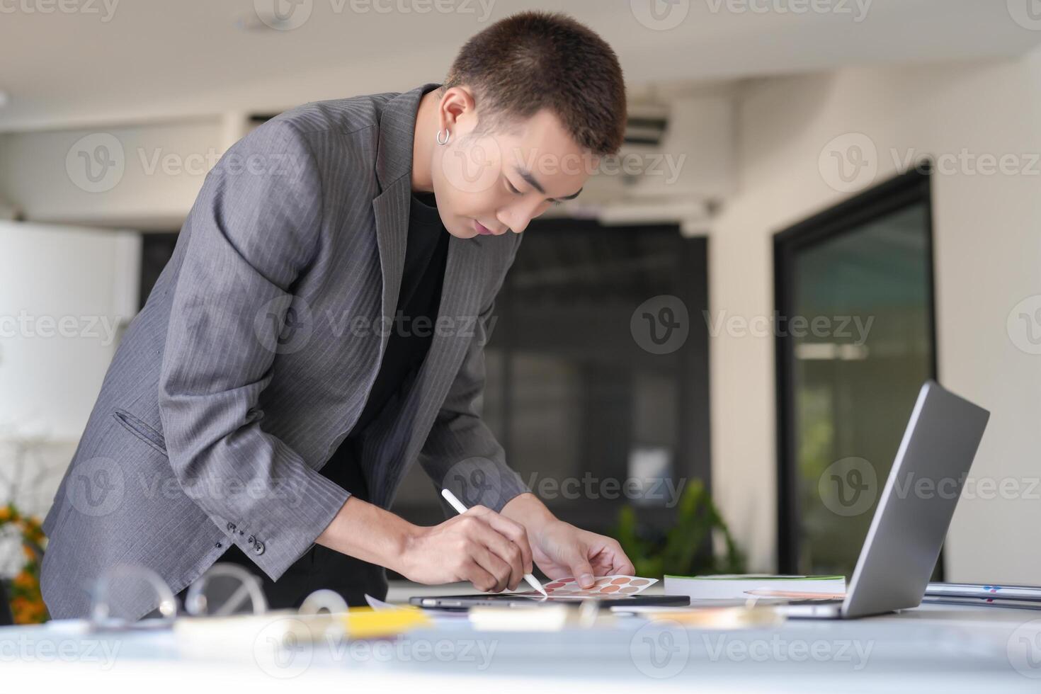 a man in a suit is writing on a piece of paper photo