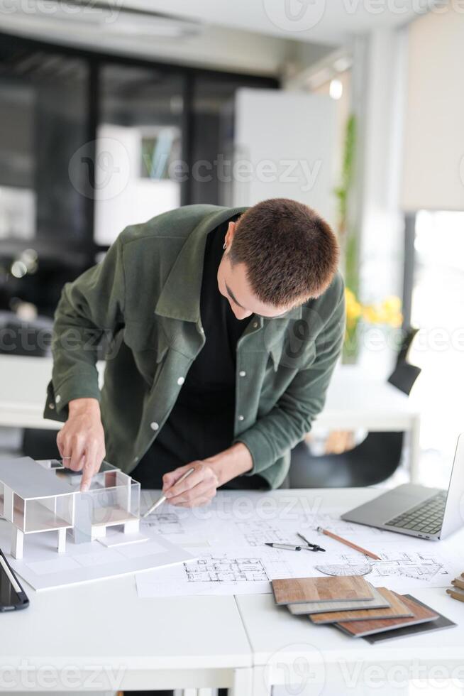 a handsome man is working on a project at a desk photo