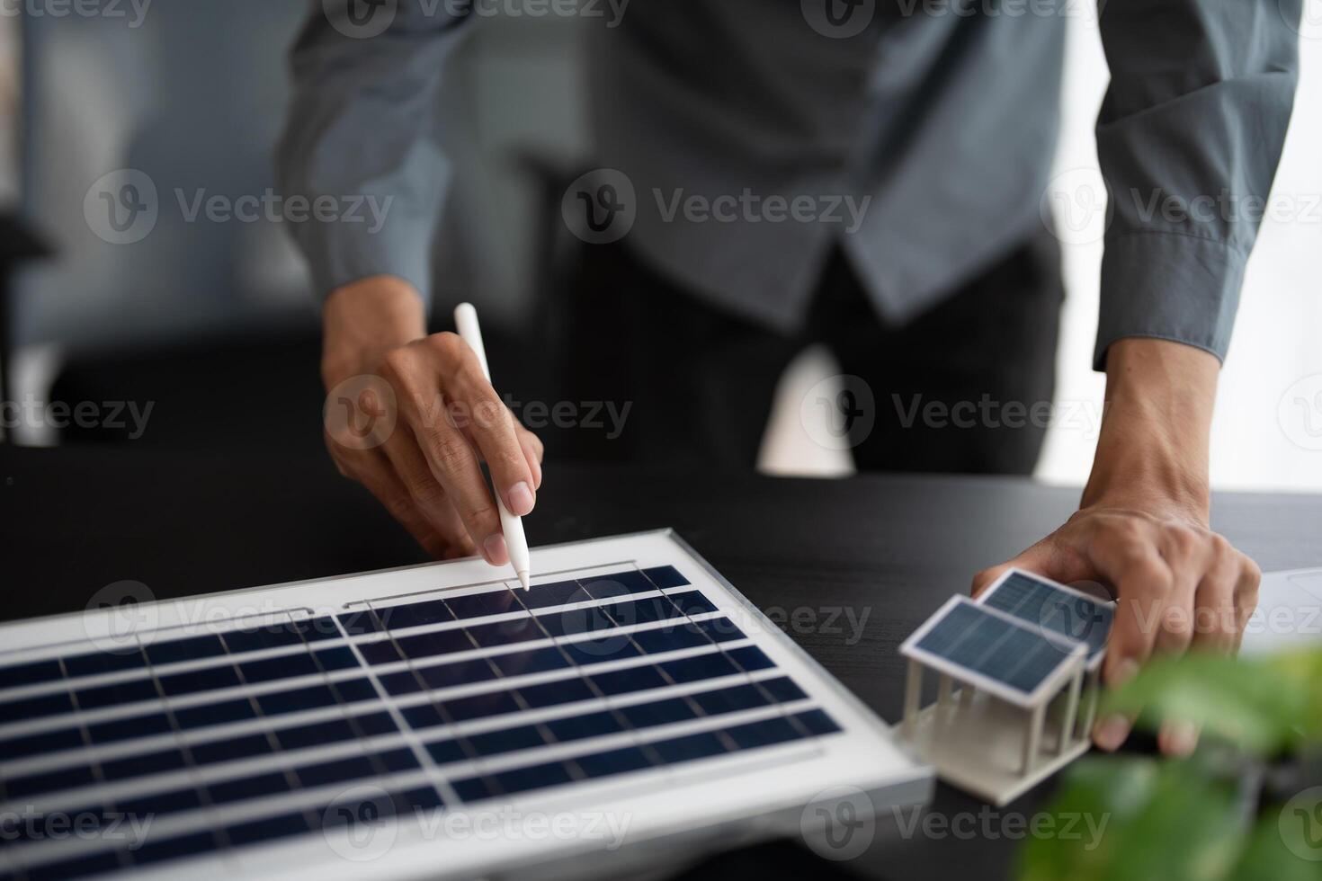 a man is using a pen to write on a solar panel photo