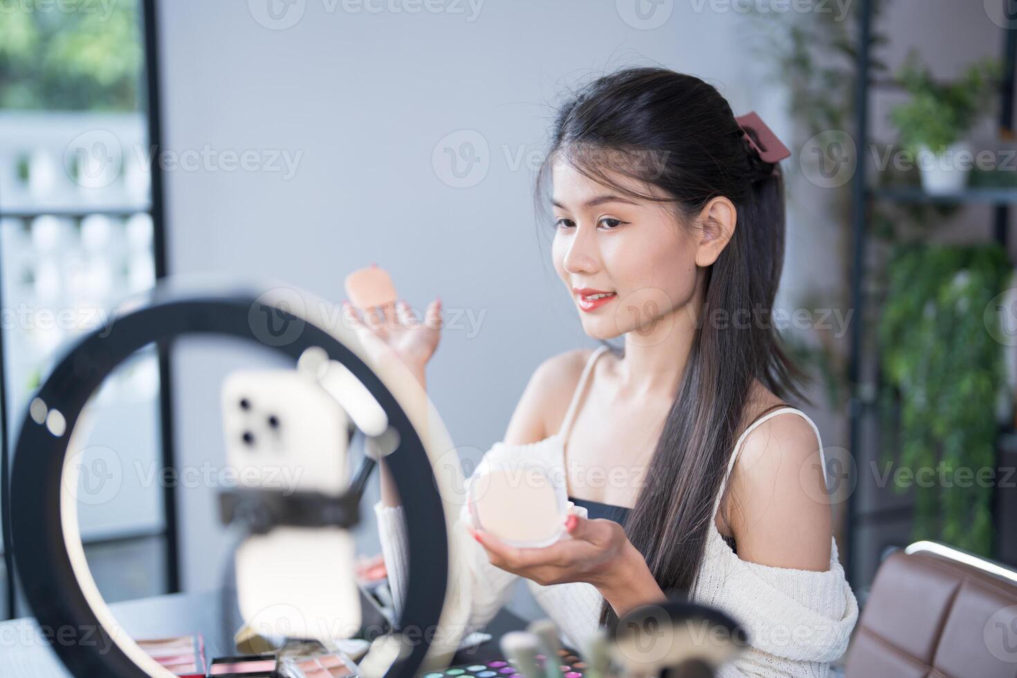 beauty asian woman applying makeup in front of mirror photo