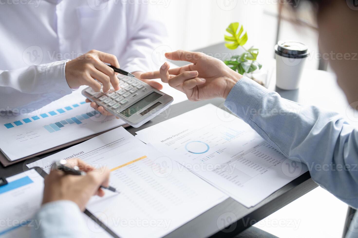 two people are working on a calculator and papers photo