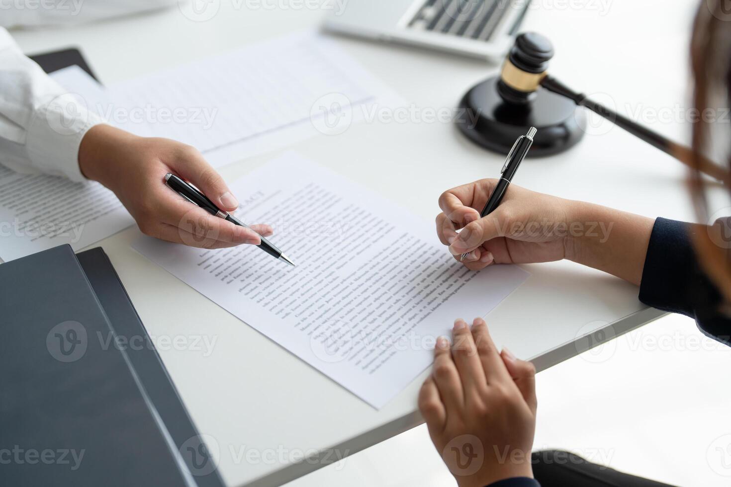two people signing a document at a table photo