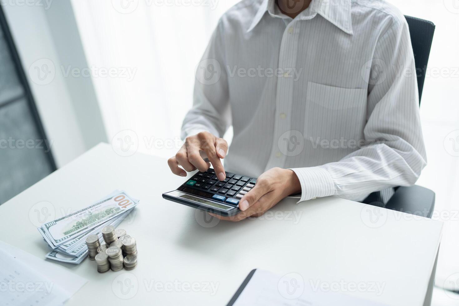a man is using a calculator to calculate the amount of money he has photo