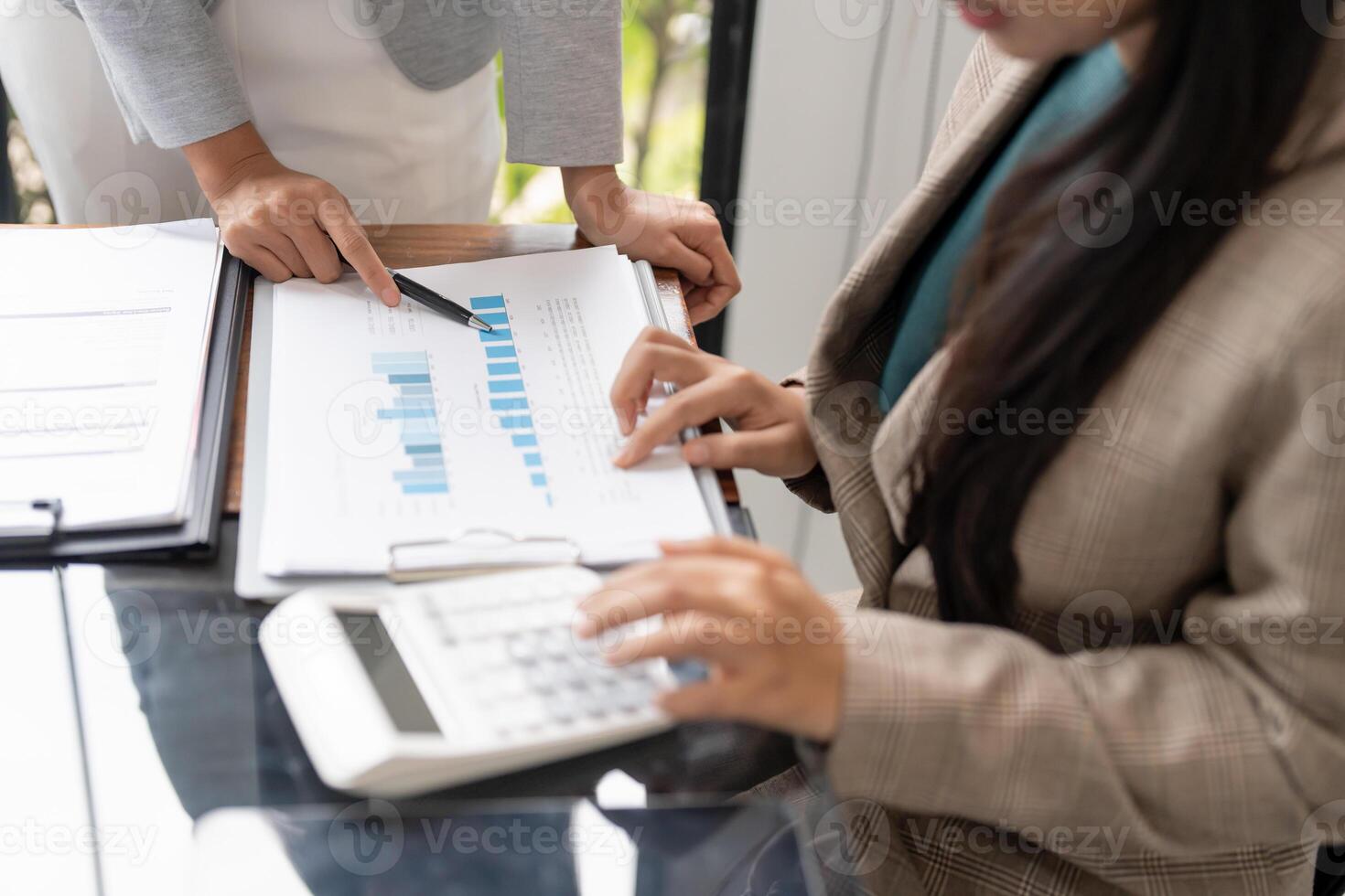 two business people are working on a document with a calculator photo