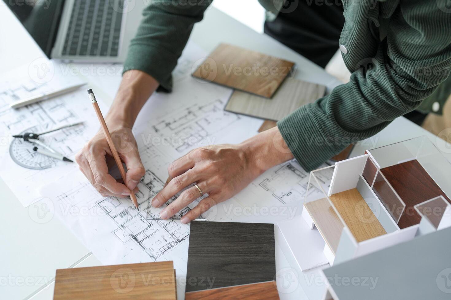 a man is working on a blueprint with a pencil photo