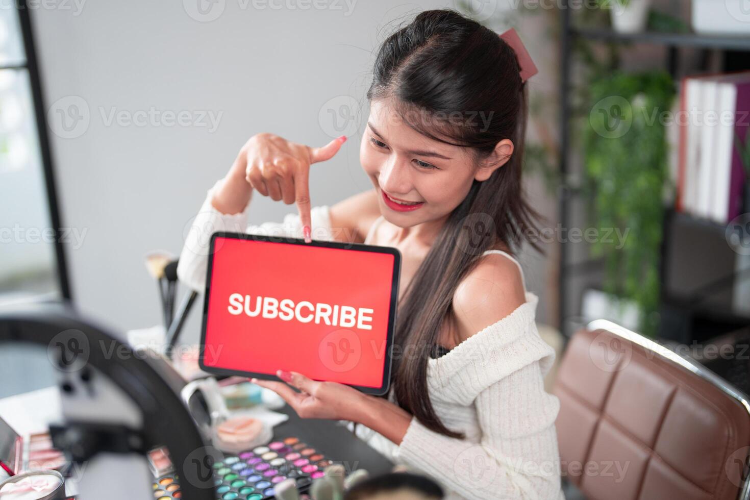 woman holding tablet with subscribe sign photo