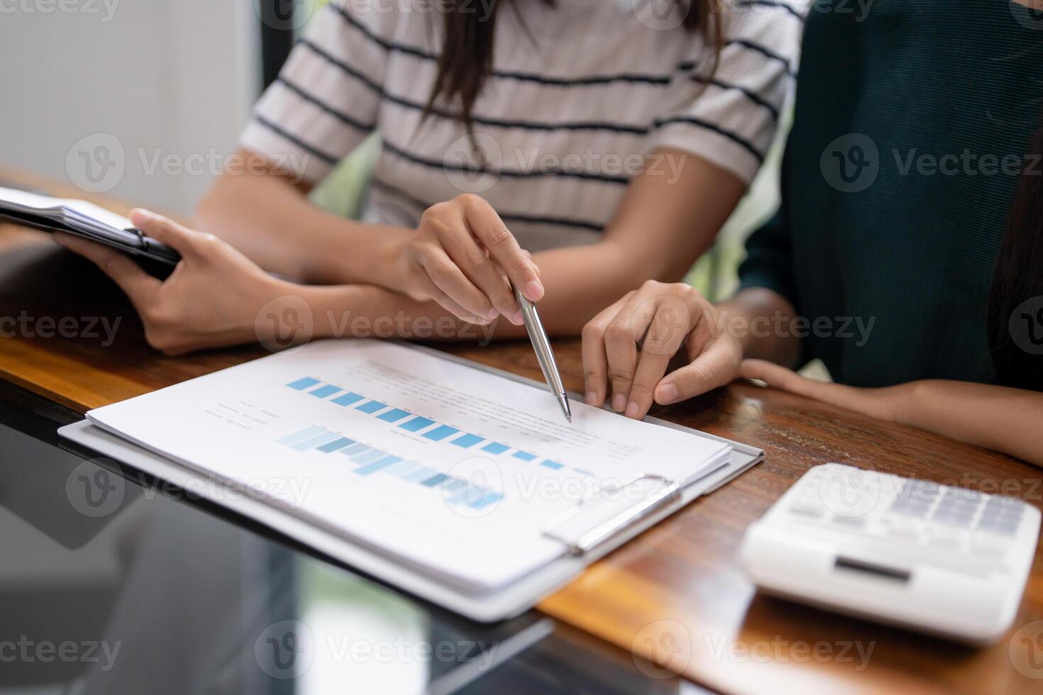 two women are working on a document with a calculator photo