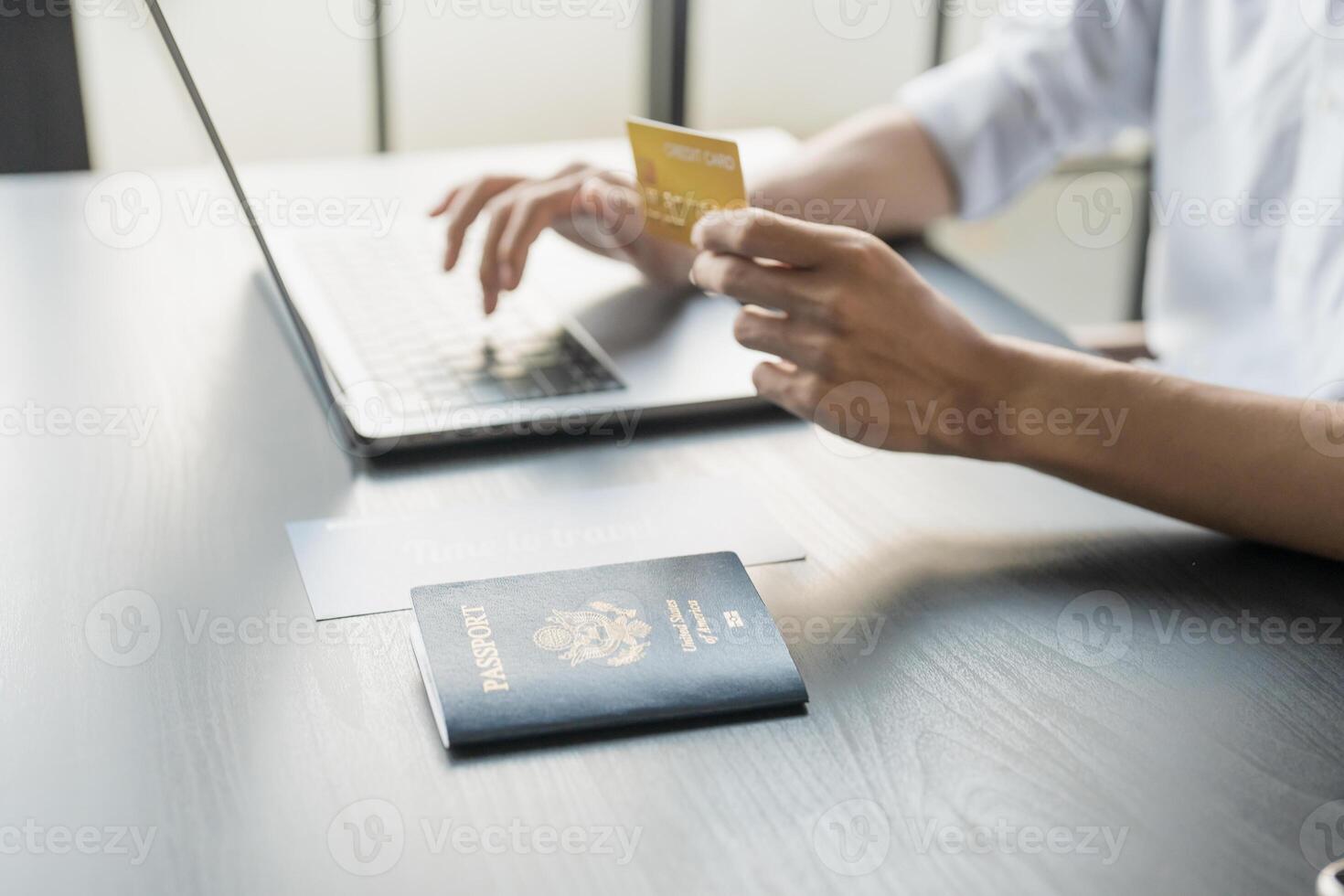Hand Man Online booking and buying plane tickets using laptop phone and credit card Planning trip travel vacation photo