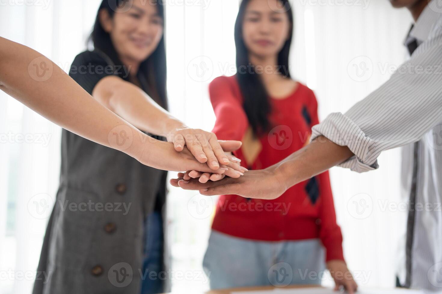 group of people Asian business hands stack unity fold their hands on each other photo