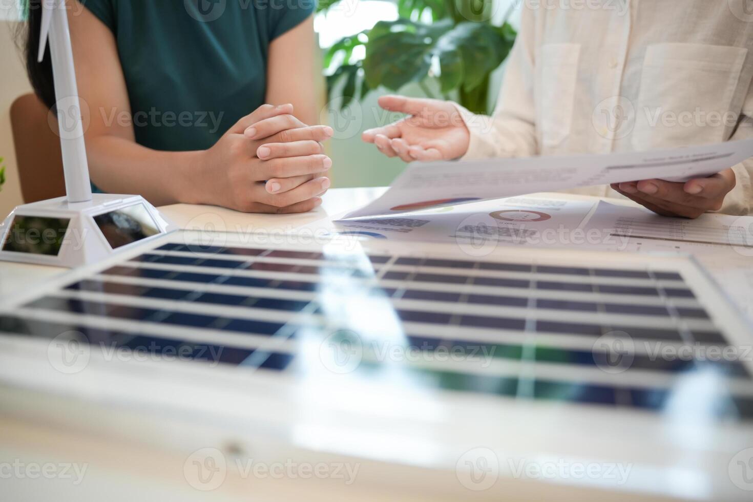 two people sitting at a table with a solar panel photo