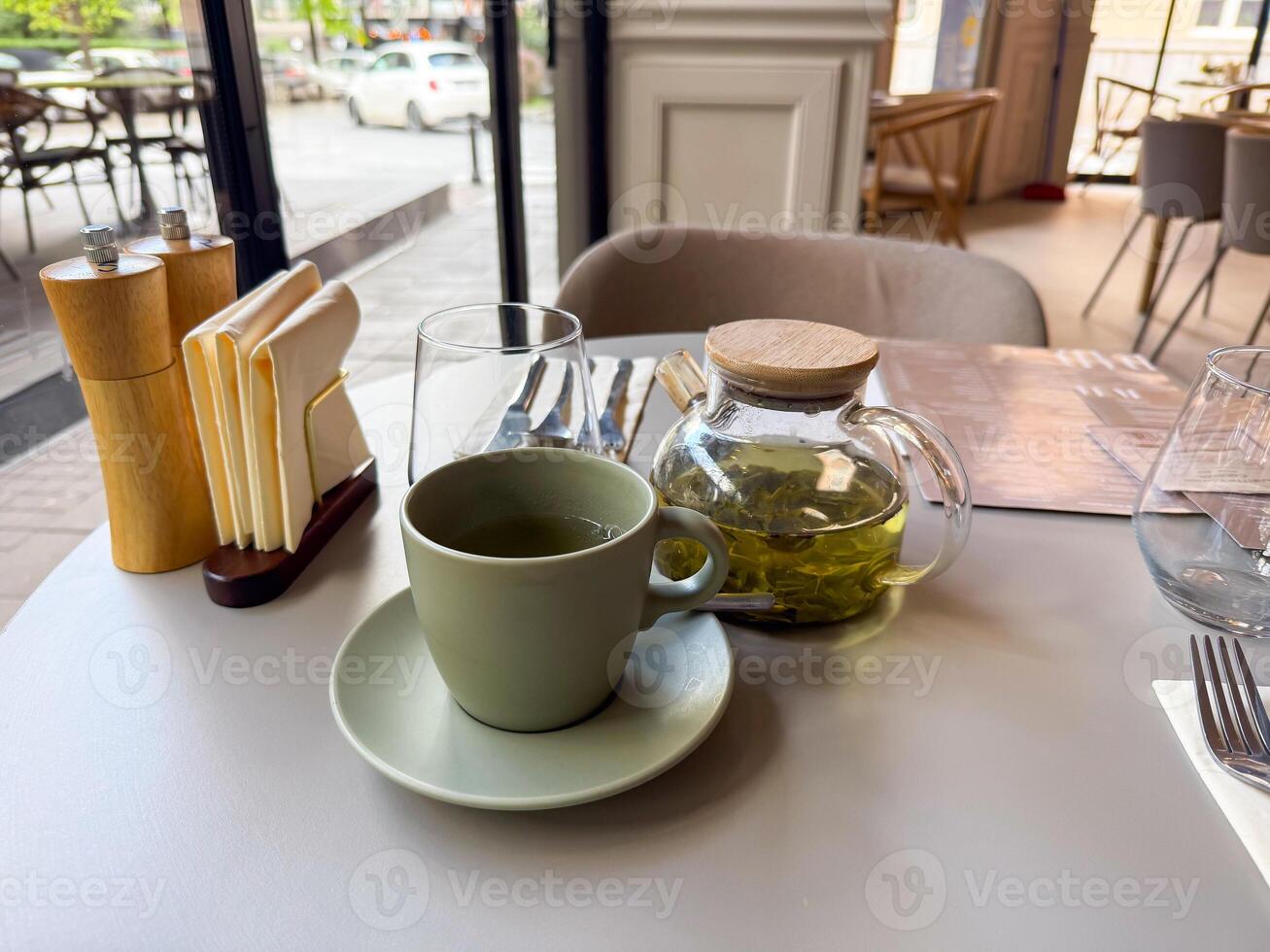 Hot green tea served at a cozy urban cafe table. Moment of pause, flavor and quiet enjoyment in the city photo