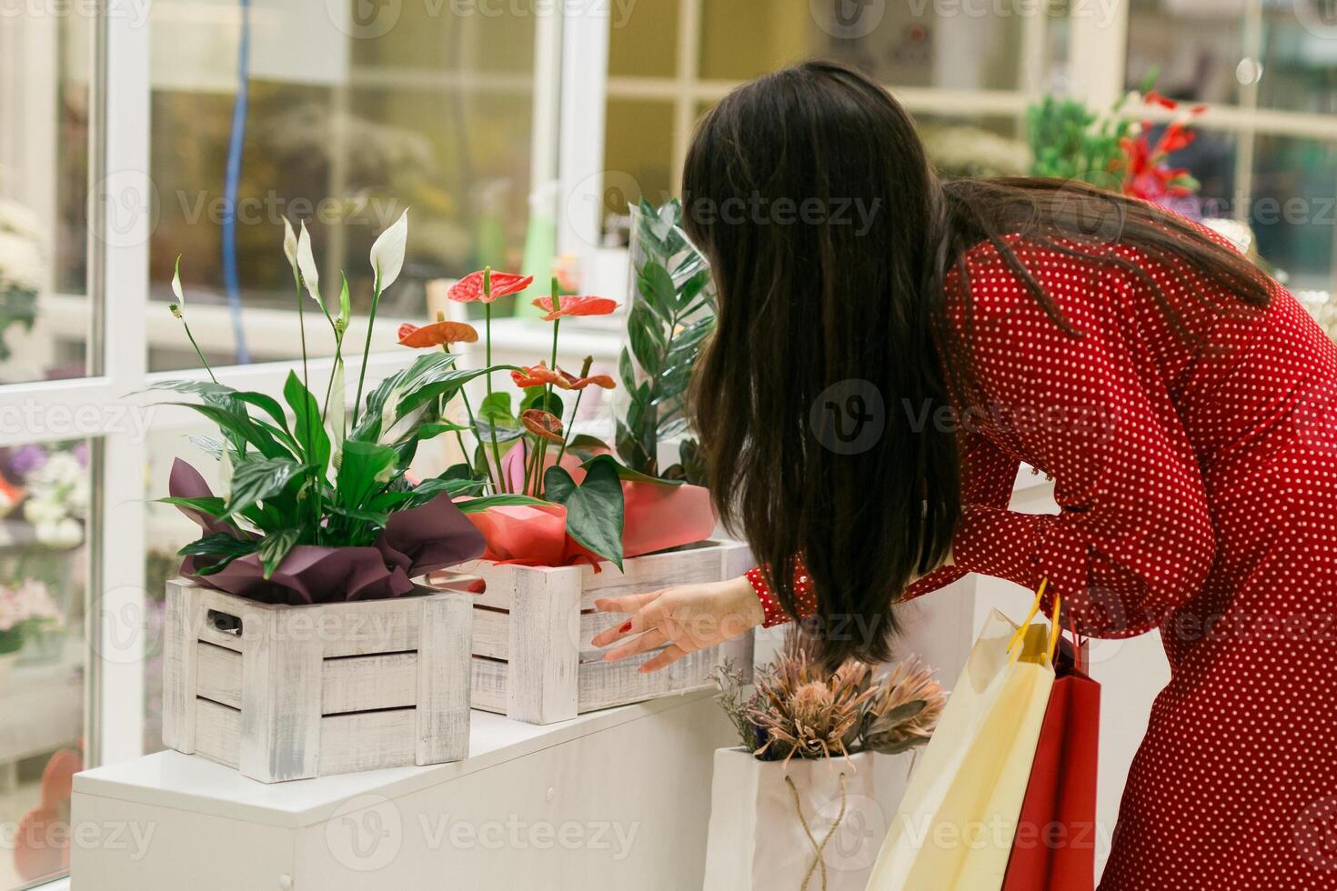 Woman choosing flowers while shopping in mall. Leisure and beauty photo