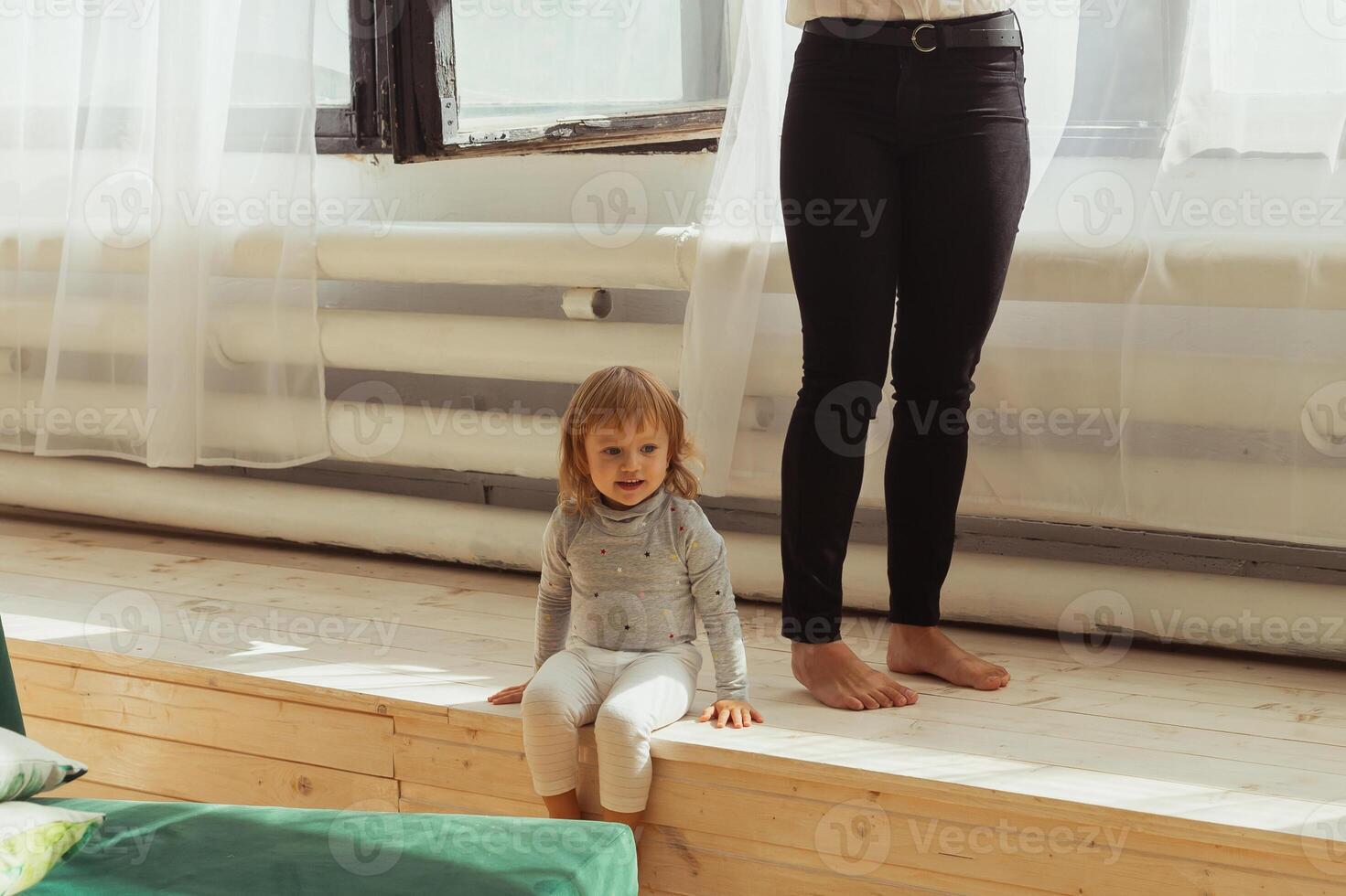 Little child playing indoors while parent works remotely. photo