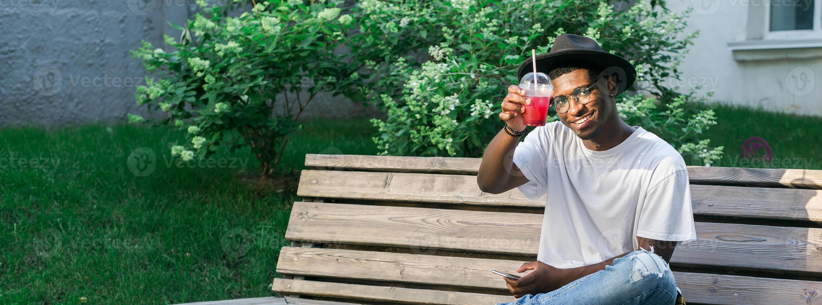 African american man enjoying a refreshing drink outdoors. Relaxation, leisure, and summer refreshment concepts. Banner with copy space photo